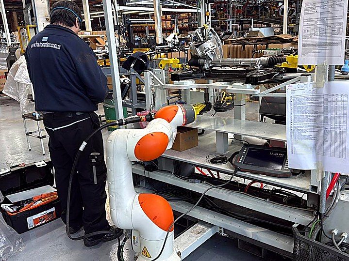Robot colaborativo KUKA junto al operario en la línea de ajuste de tuercas